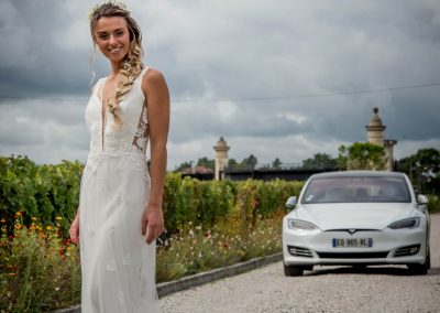 Une mariée devant une Tesla S blanche